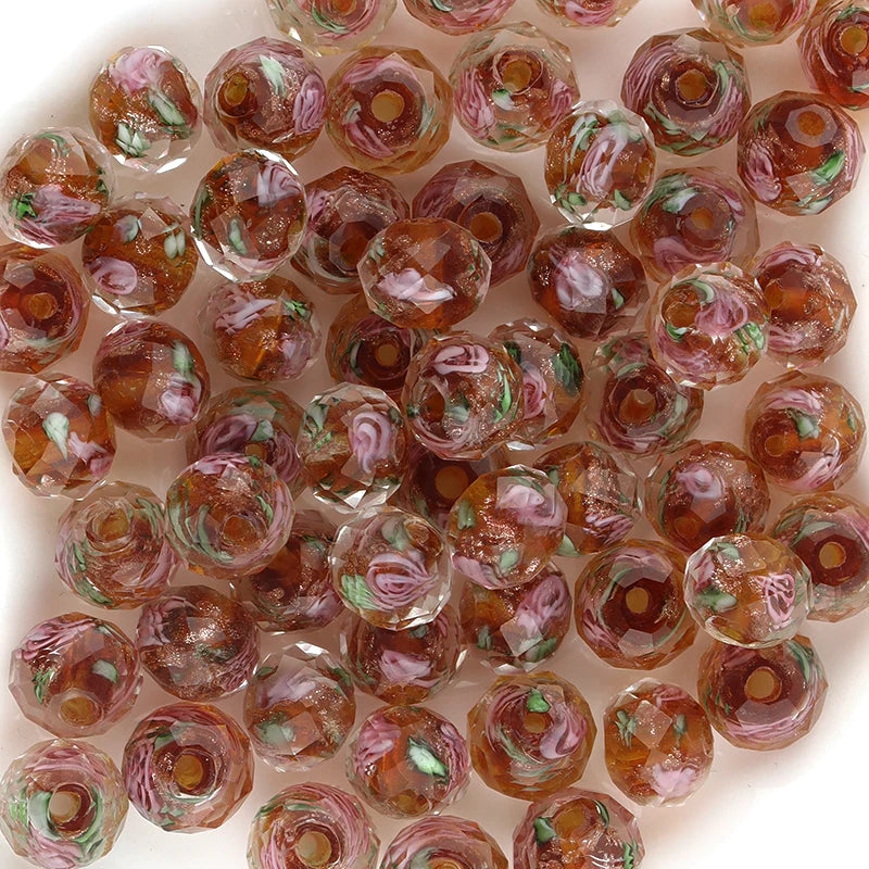 Close-up of glass beads with floral patterns on a white background