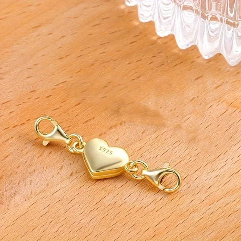 Gold heart-shaped clasp on a wooden surface