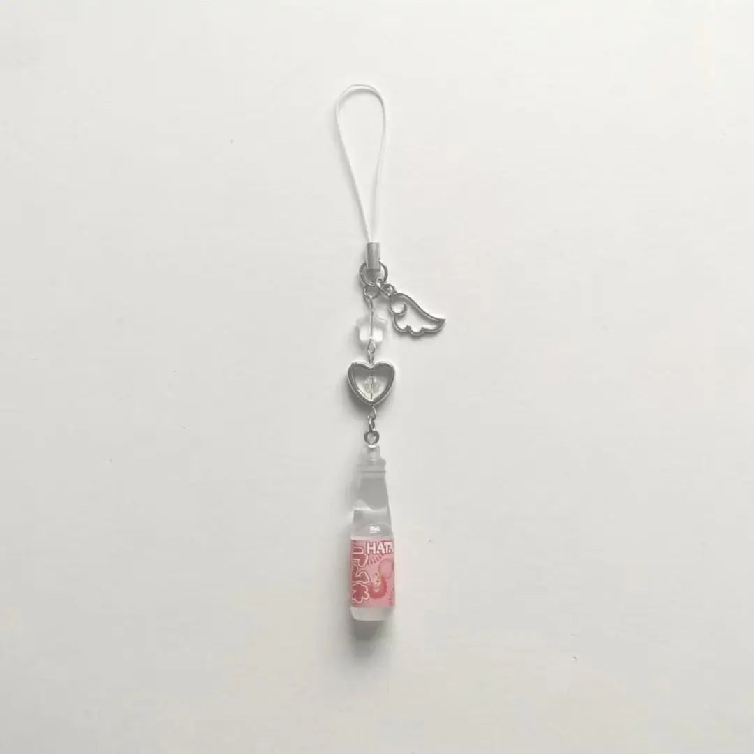 Phone charm with a small bottle and heart-shaped details on a white background