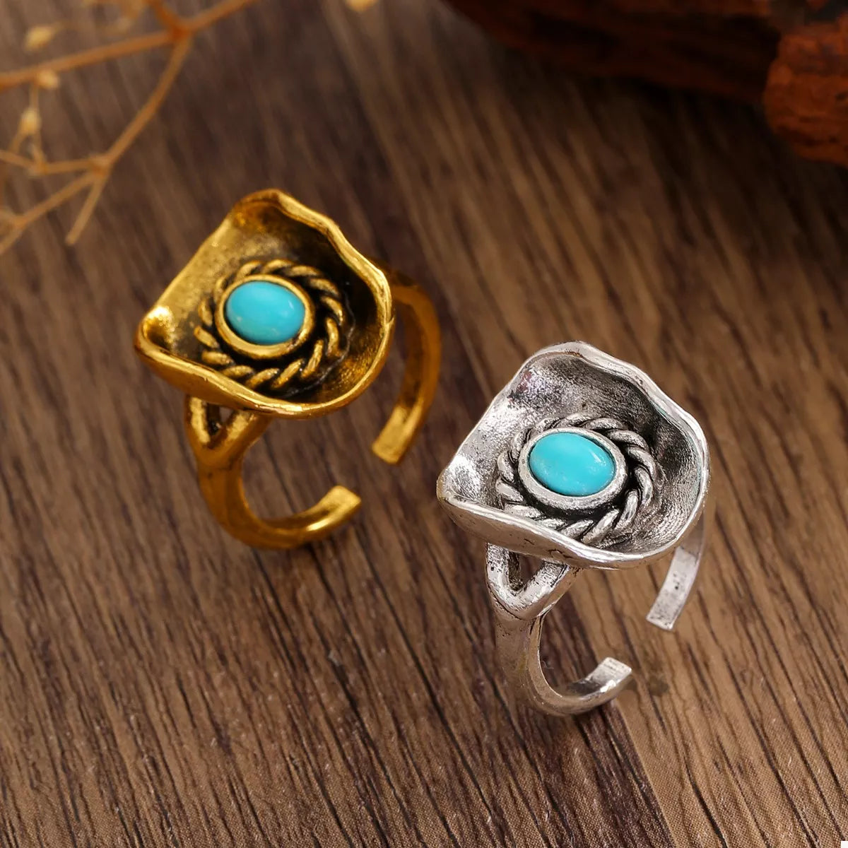 Gold and silver western style rings with turquoise stones on a wooden surface
