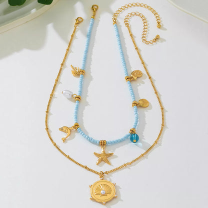 Two necklaces with blue beads and gold accents on a white surface