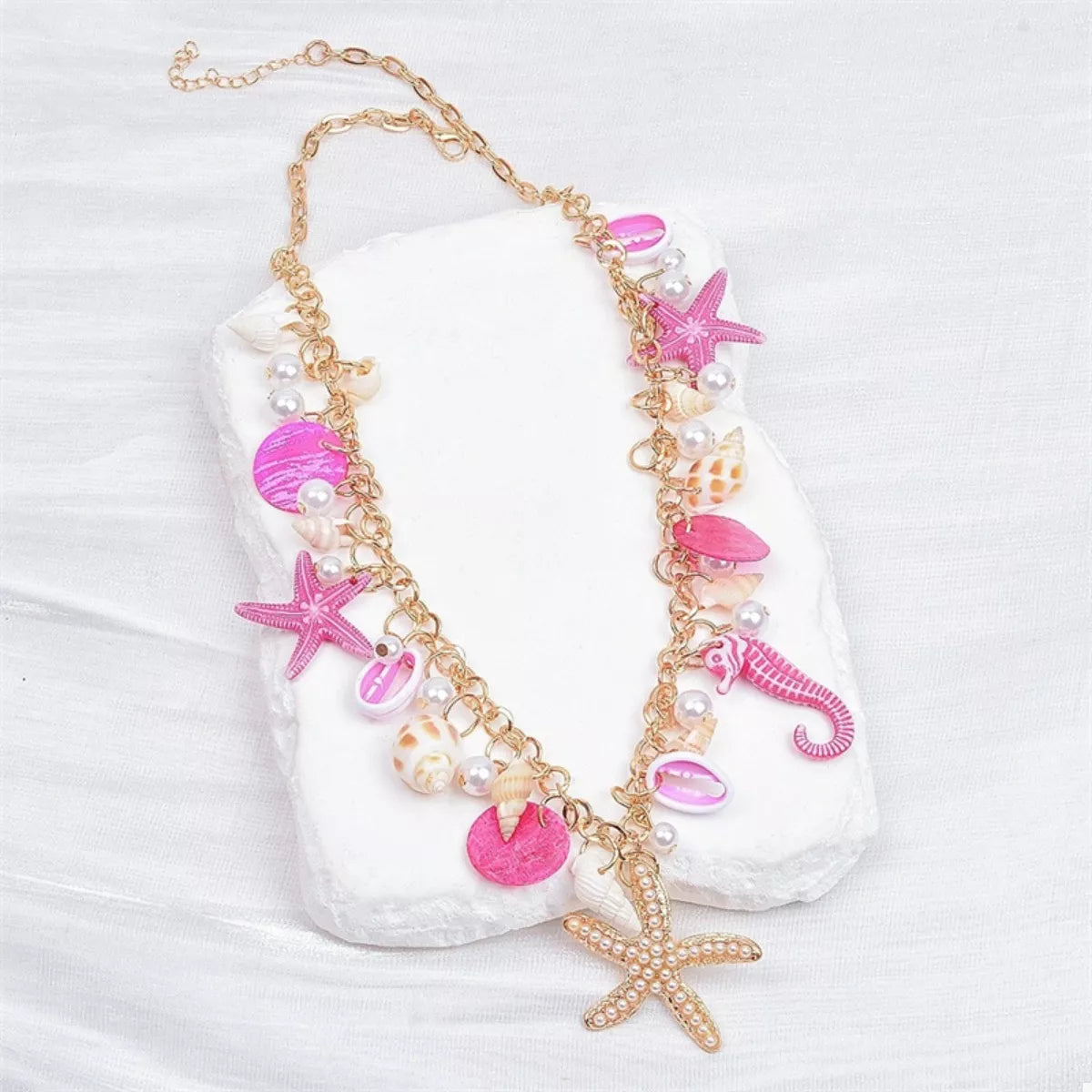 Necklace with pink and gold charms on a white background