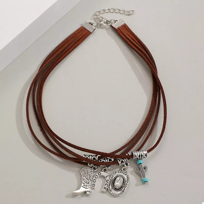 Brown leather necklace with silver western charms on a white background