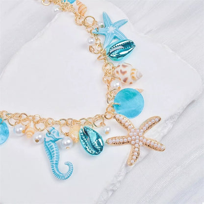 Necklace with seashell, starfish, and seahorse charms on a white background