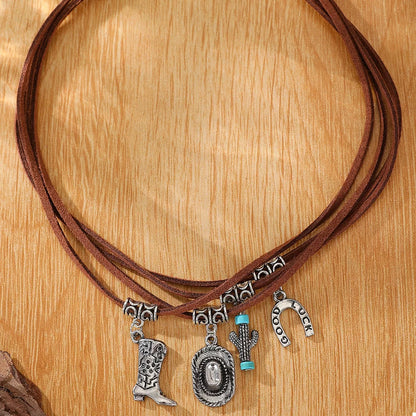 Brown leather cord necklace with silver western charms on a wooden surface