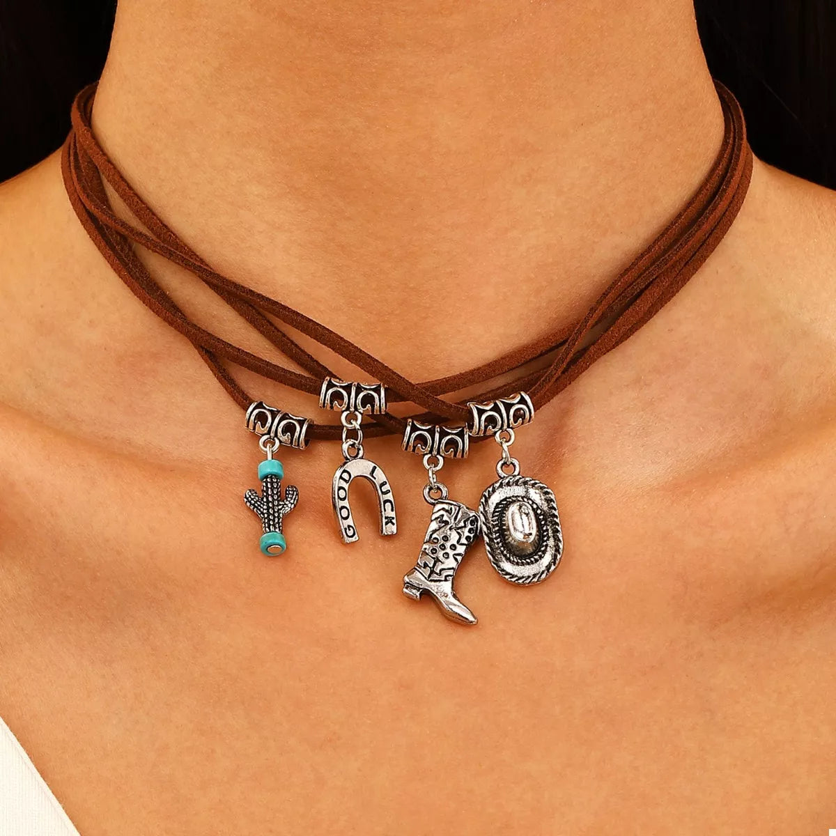 Necklace with western charms on a person's neck against a neutral background