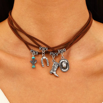Necklace with western charms on a person's neck against a neutral background