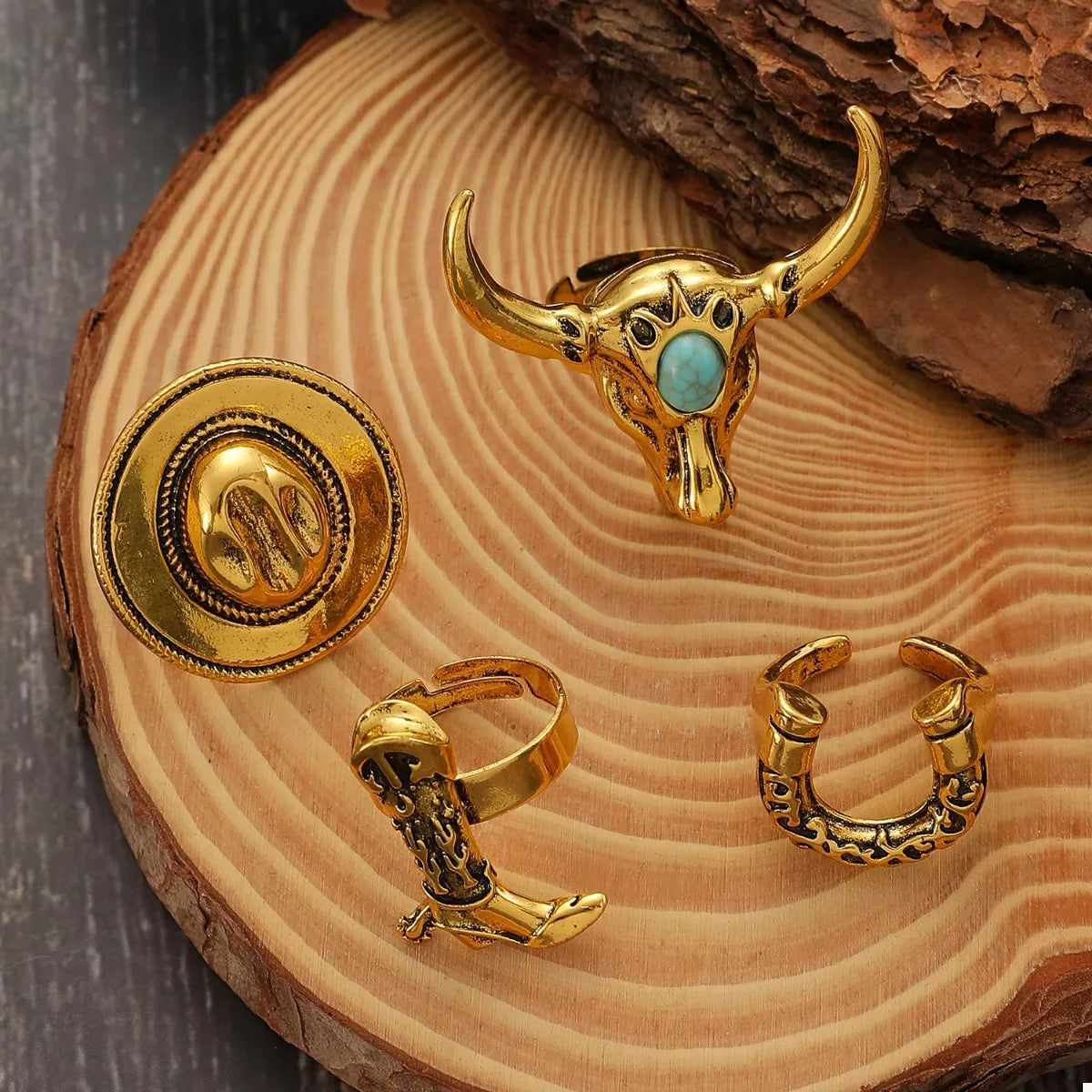 Gold bull skull ring with turquoise stone on a wooden surface