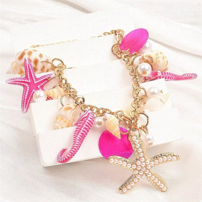 Necklace with pink starfish, seahorse, and shell charms on a white background