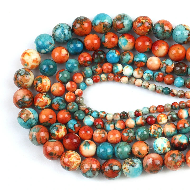 Multiple strands of polished round gemstone beads in a marbled pattern of turquoise blue, orange, red, and cream, arranged on a plain white background.