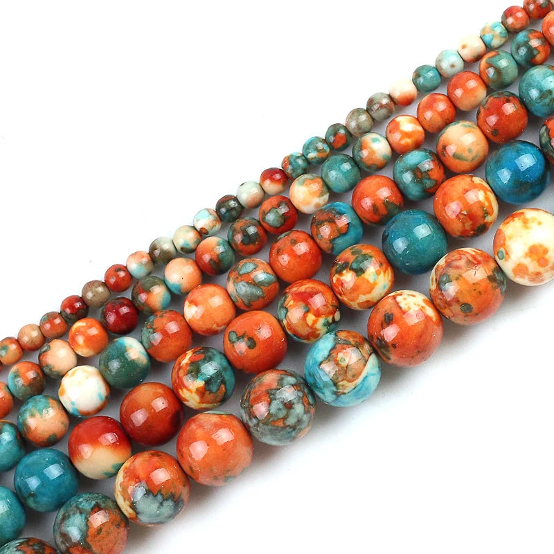 Three diagonal strands of polished round gemstone beads in marbled patterns of orange, teal blue, red, and cream on a white background.