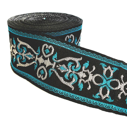 A roll of black decorative trim featuring a repeating pattern of turquoise blue and white scrollwork, shown on a plain white background.