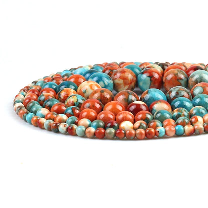 A coiled strand of polished round beads in a marbled pattern of turquoise blue, orange, red, and cream, photographed on a clean white background.
