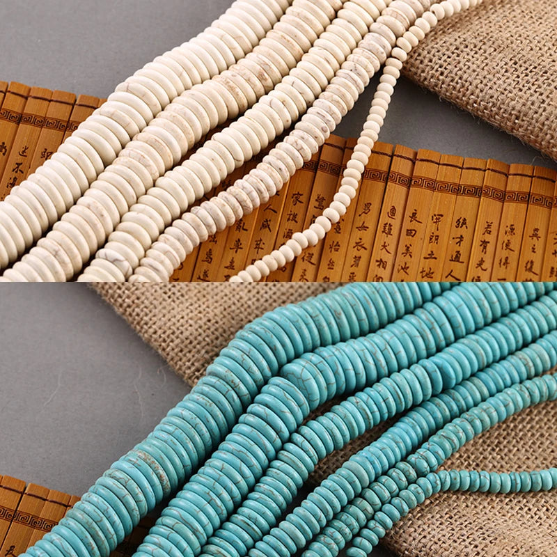 Two strands of round disc beads shown in a split view: one strand is cream/off-white and the other is turquoise blue. Both are laid diagonally over a brown bamboo-style mat with black calligraphy and a burlap cloth in the background.