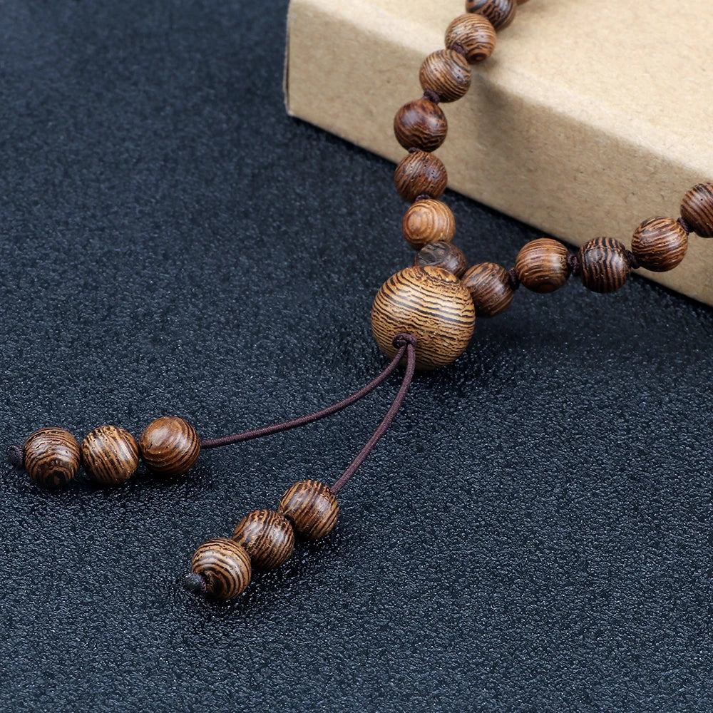 Wooden beaded necklace on a dark surface with a cardboard box in the background