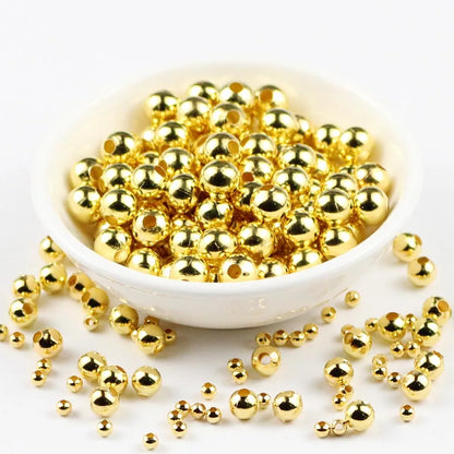 Gold beads in a white bowl on a white background