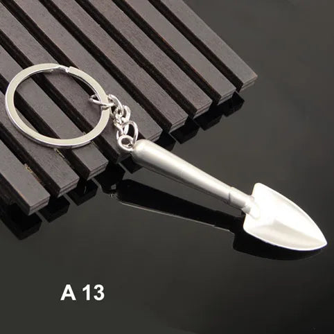 Metal keychain with a shovel design on a black background