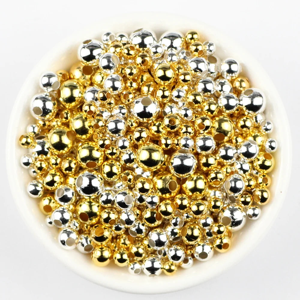 Gold and silver round beads on a white background