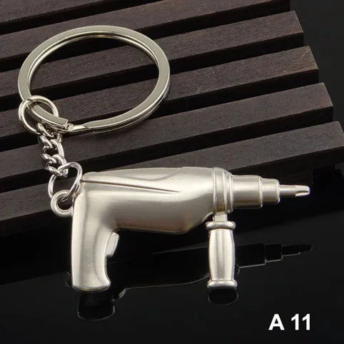 Metallic drill-shaped keychain on a dark wooden surface
