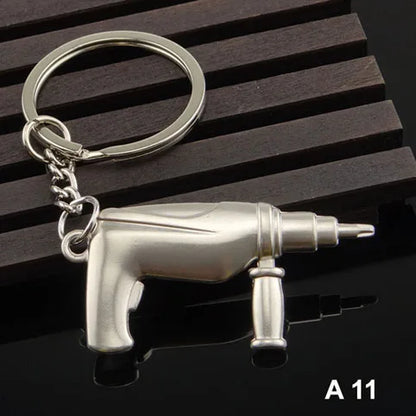 Metallic drill-shaped keychain on a dark wooden surface