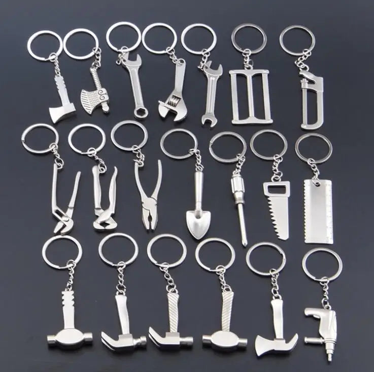 Collection of silver tool-themed keychains on a dark background