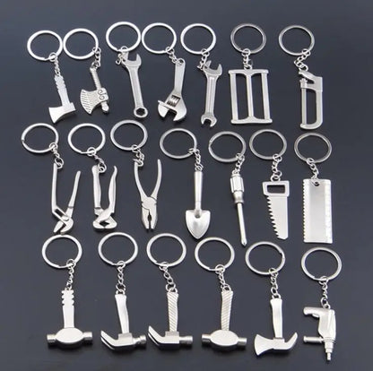 Collection of silver tool-themed keychains on a dark background