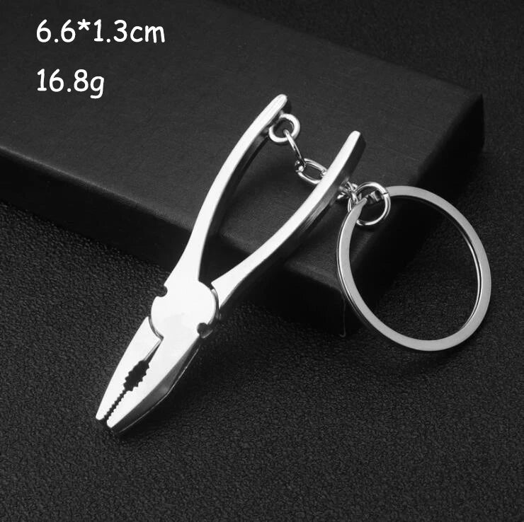 Metal pliers keychain on a black background with dimensions and weight displayed.