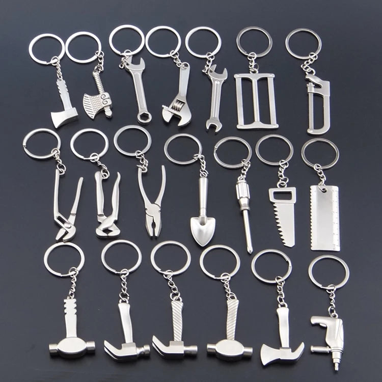 Collection of silver tool-themed keychains on a dark background