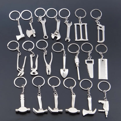 Collection of silver tool-themed keychains on a dark background