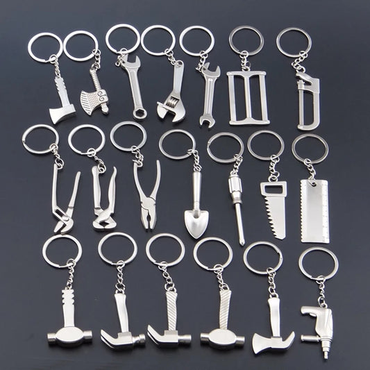 Collection of silver tool-themed keychains on a dark background
