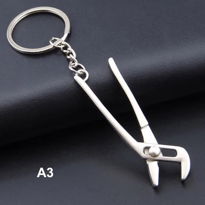 Metal channel lock pliers keychain on a dark surface