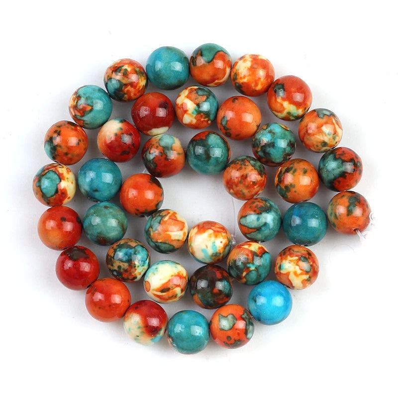 A coiled strand of round marbled beads in orange, teal, turquoise, red, cream, and brown on a plain white background.