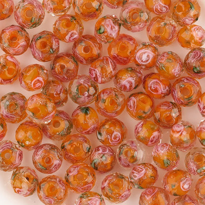 Close-up of orange and pink marbled beads on a light pink background