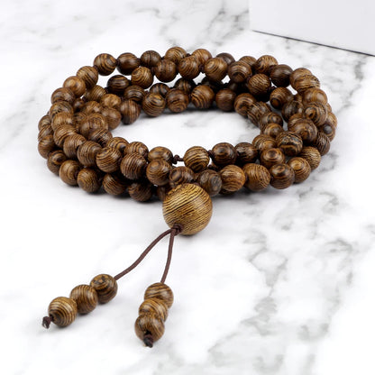 Wooden beaded bracelet with a tassel on a marble surface