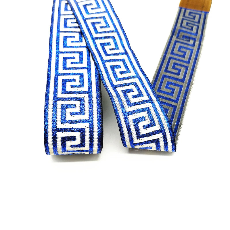 Blue and white glittery grosgrain ribbon with a Greek or vintage bohemian key pattern, shown in a looped arrangement on a white background.