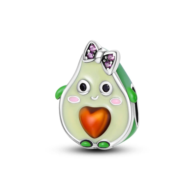 Avocado-shaped charm with a face, heart, and pink bow on a white background