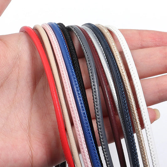 Set of colorful leather jewelry making bands held in a hand against a white background