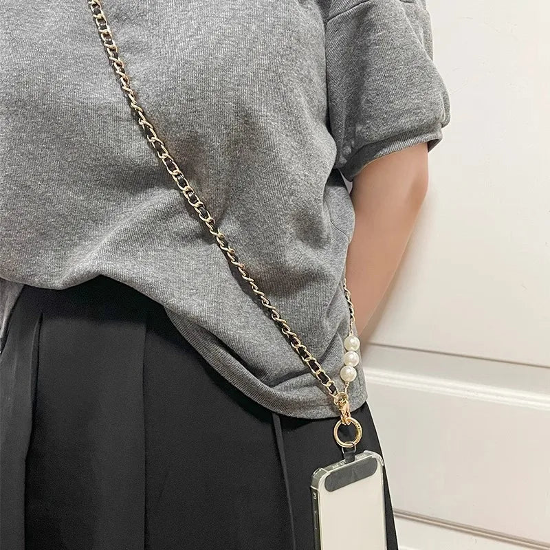 Person wearing a gold chain with pearls and a phone case.