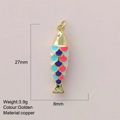 Gold fish-shaped pendant with colorful scales on a light pink background