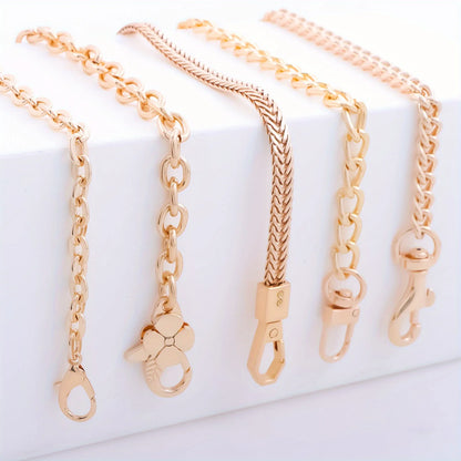 Four rose gold chain accessories with different link styles and clasp designs, arranged on a white display block.