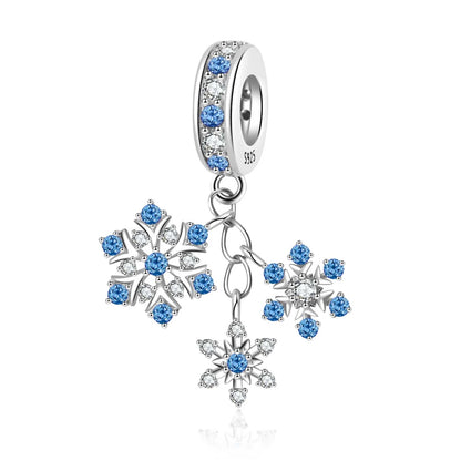 Silver charm with blue gemstones and snowflake designs on a white background