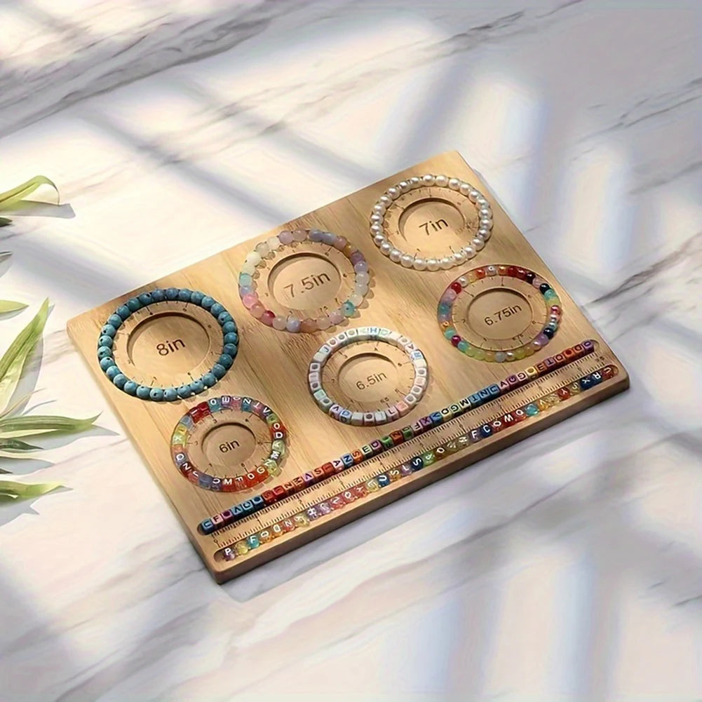 Wooden bracelet making kit with colorful beads and measurement markings on a marble surface.
