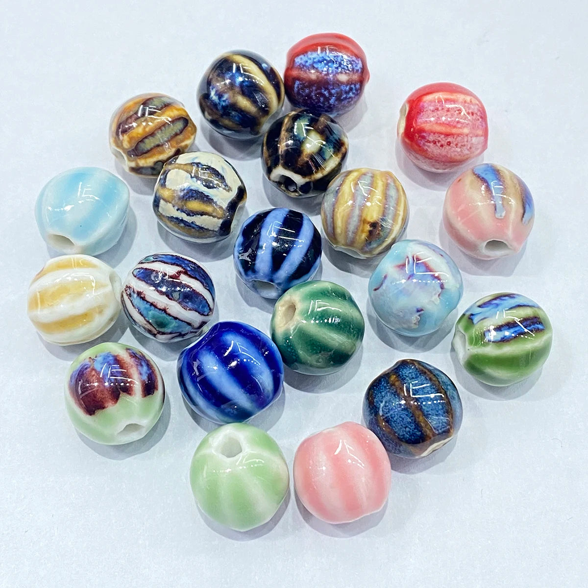 A group of colorful, round glass beads with various marbled and swirled patterns, arranged on a plain white background.