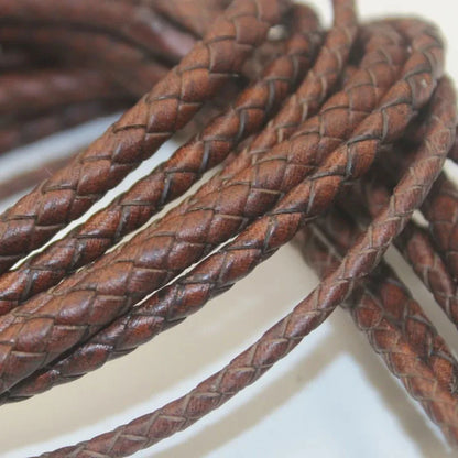 Close-up of braided brown leather cord on a light background