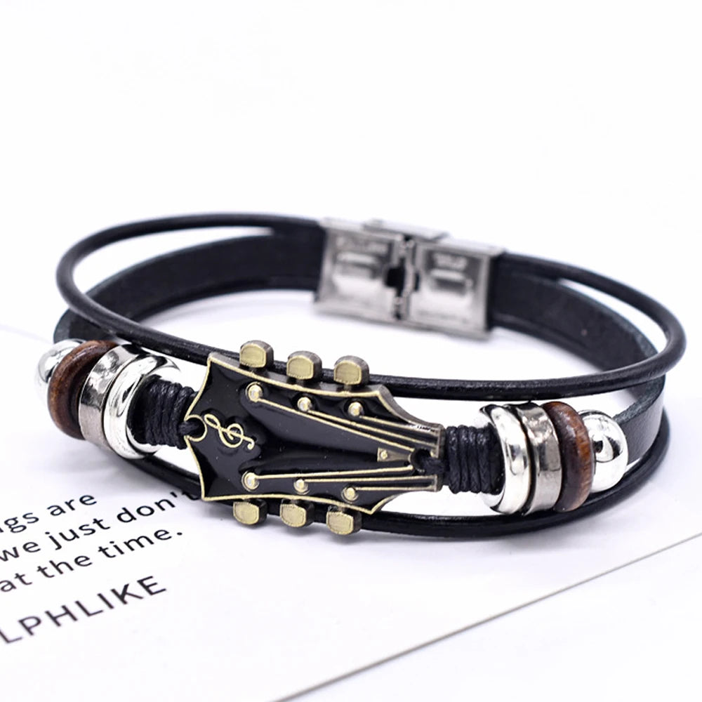 Guitar-shaped bracelet with black leather strap on a white background