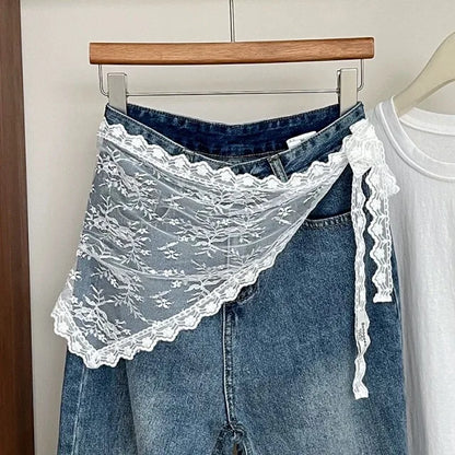 Blue jeans with a white lace shawl draped over them on a hanger.