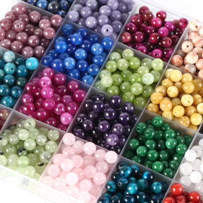 Assorted colored beads in small square compartments.