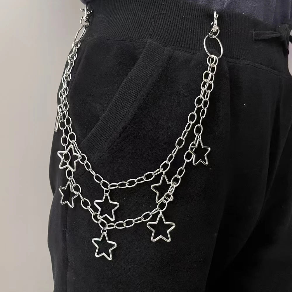 Silver chain belt with star charms worn by a person on a plain background