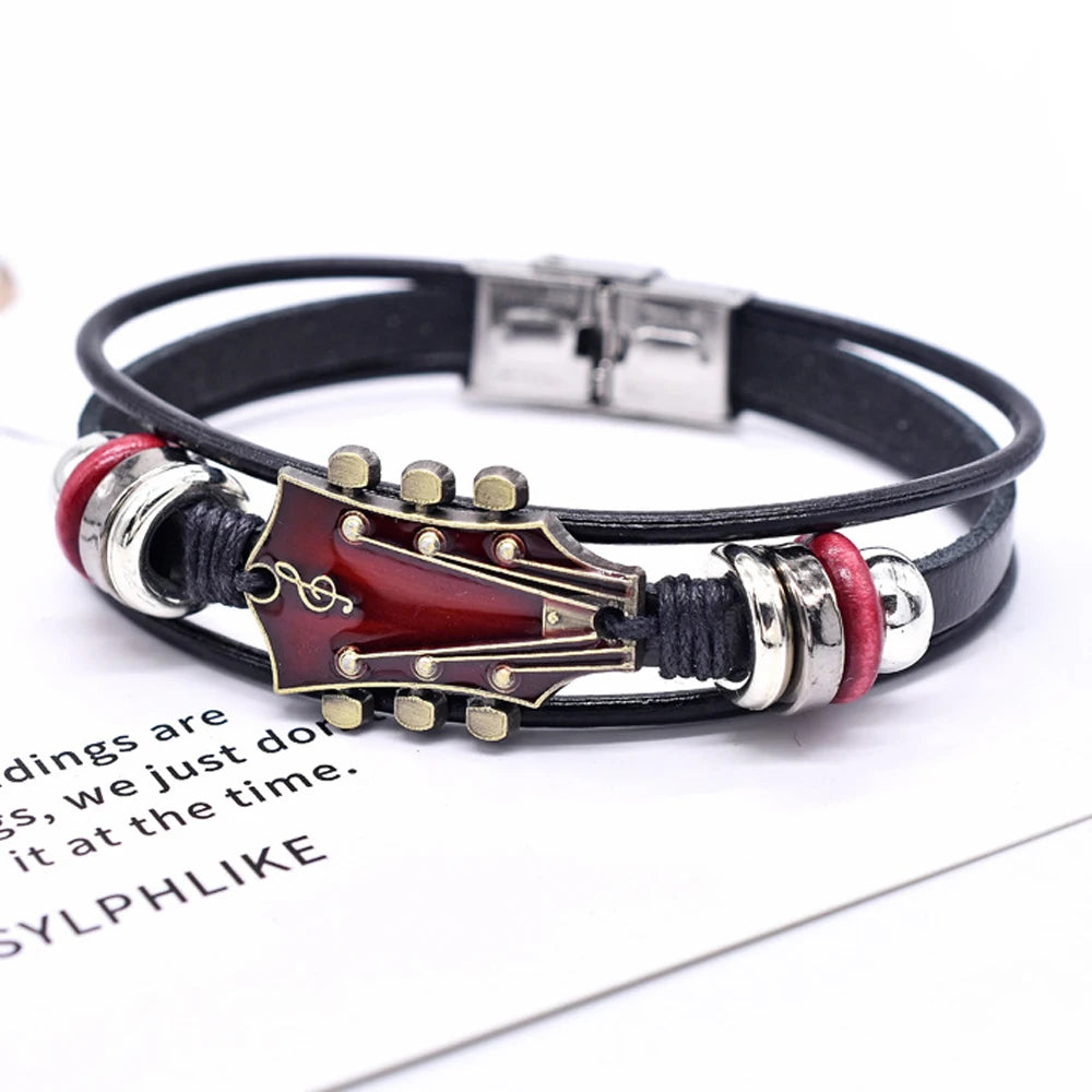 Guitar-shaped bracelet with black leather strap on a white background