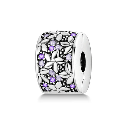 Silver charm with purple stones on a white background